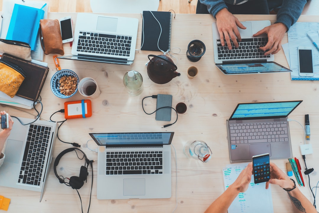 ai seo agency — people sitting down near table with assorted laptop computers