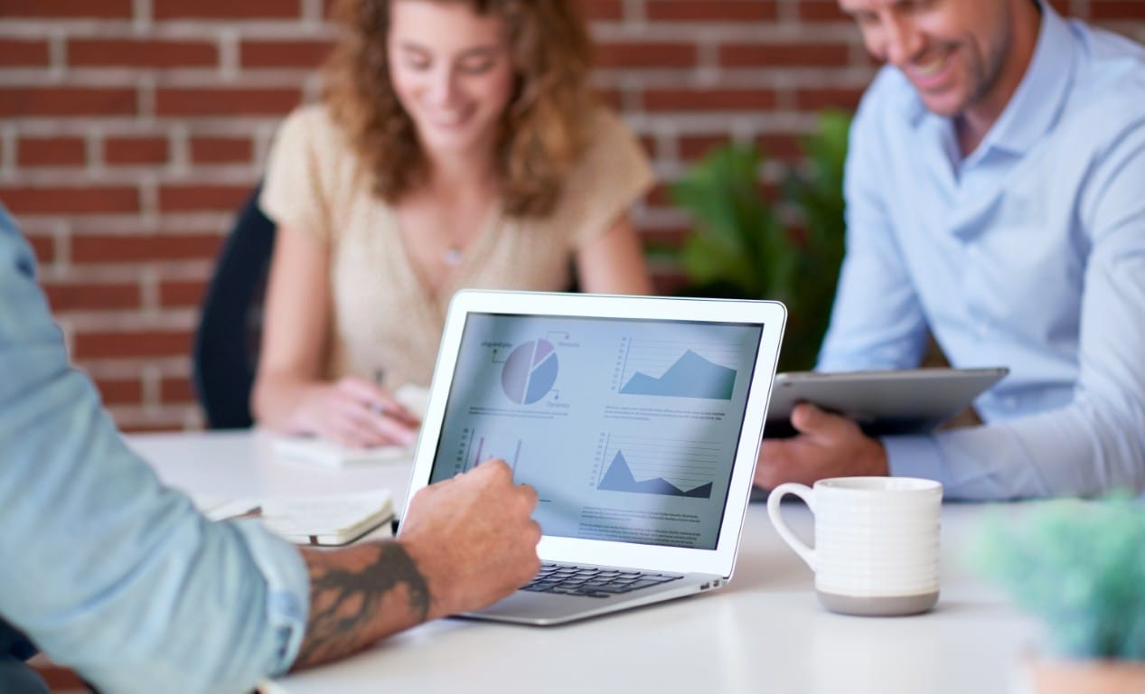 Business meeting with a laptop reviewing marketing performance data