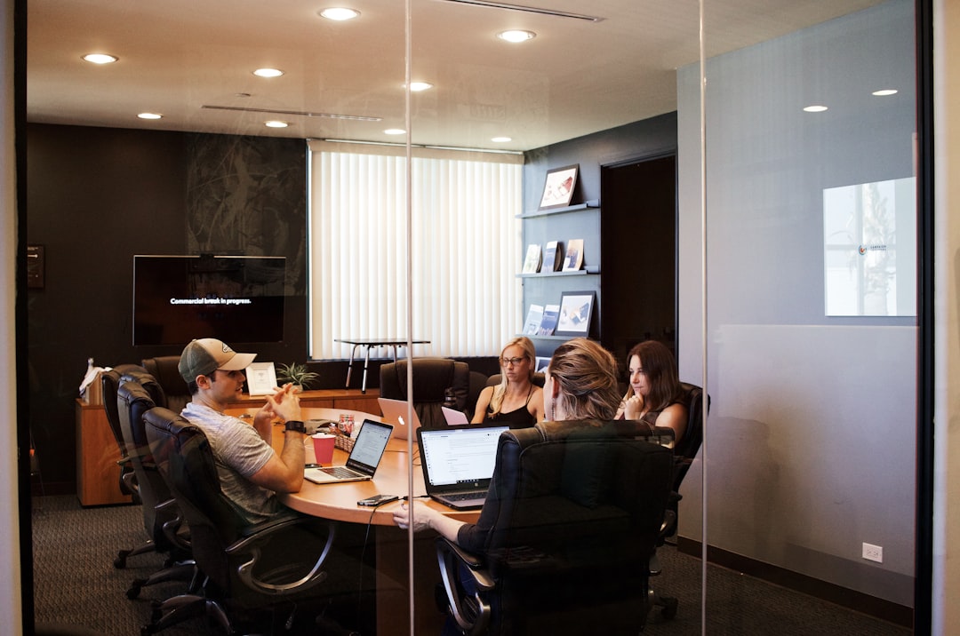 fullerton seo company — people sitting near table with laptop computer