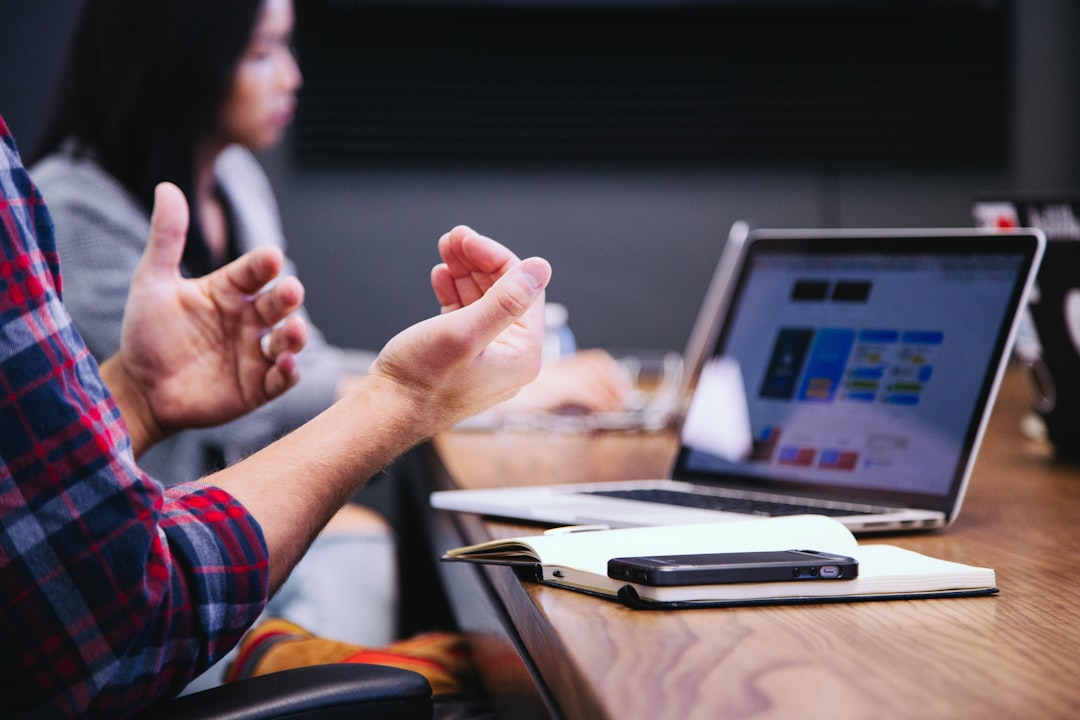 irvine seo company — person gesturing during meeting with laptop
