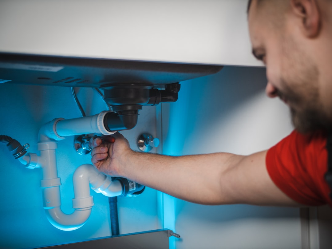seo for plumbers — a man working on a pipe in a wall