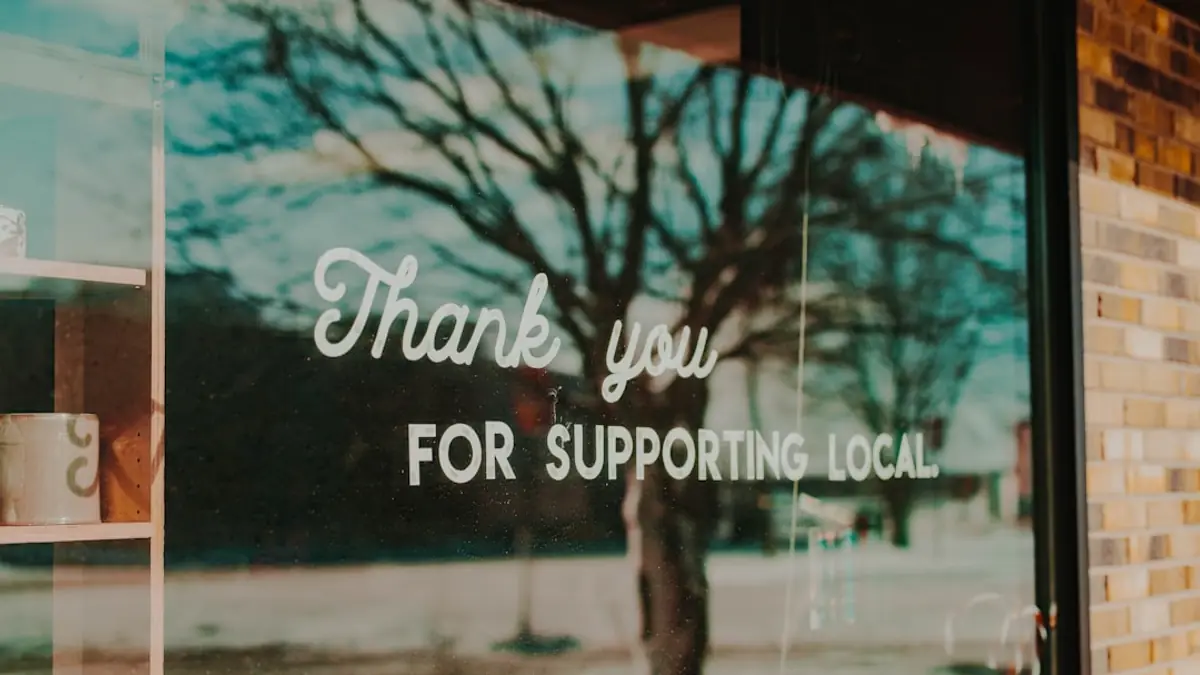 A shop window with a printed sign reading "thank you for supporting local".