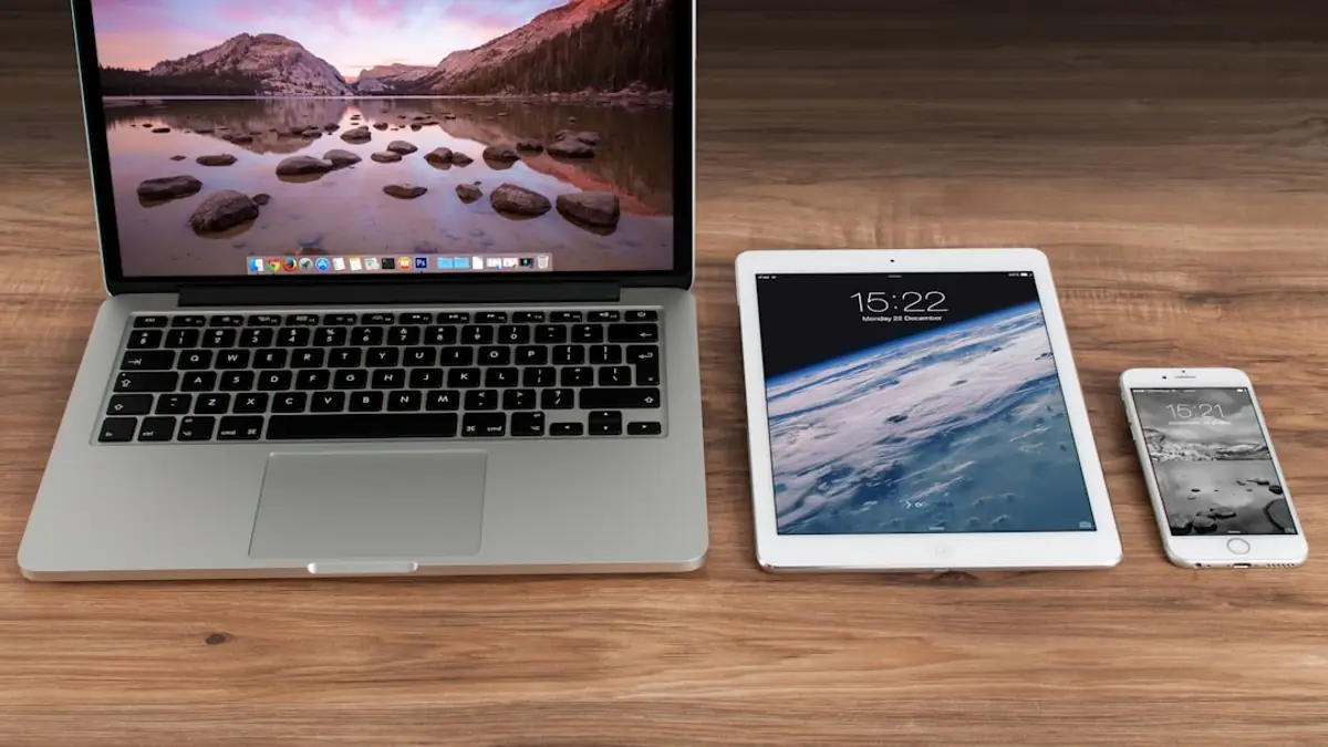 A laptop, tablet and phone side by side on a desk, each showing a web page.