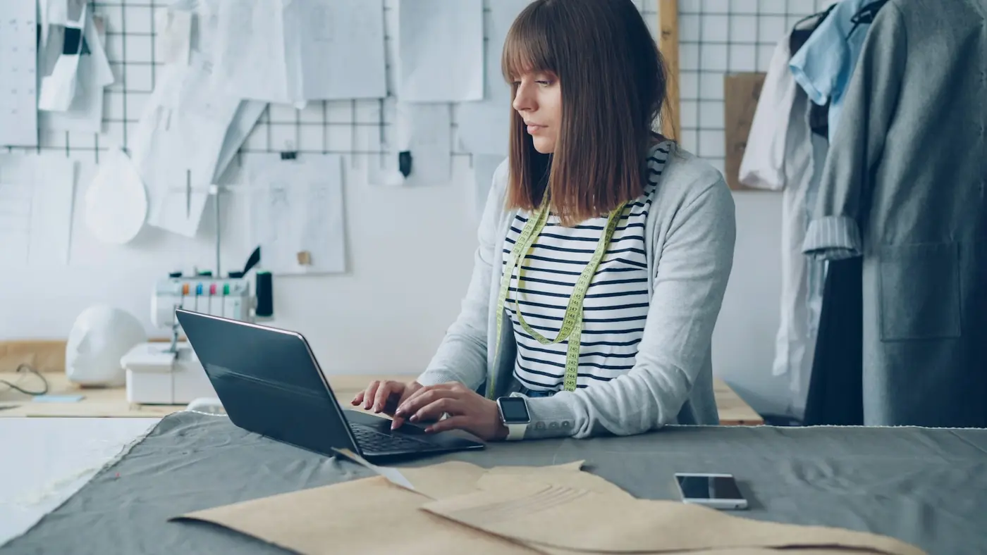 A small business owner working on her laptop in her studio